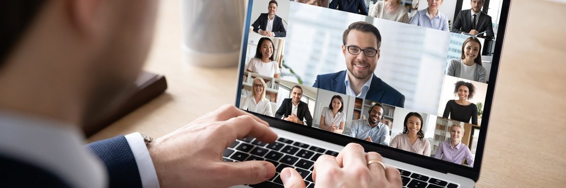 Mann sitzt vor einem Laptop mit Video-Konferenz