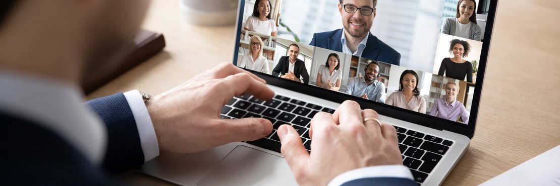 Mann sitzt vor einem Laptop mit Video-Konferenz