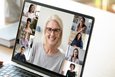 Frau vor Laptop in Online-Meeting mit anderen Frauen